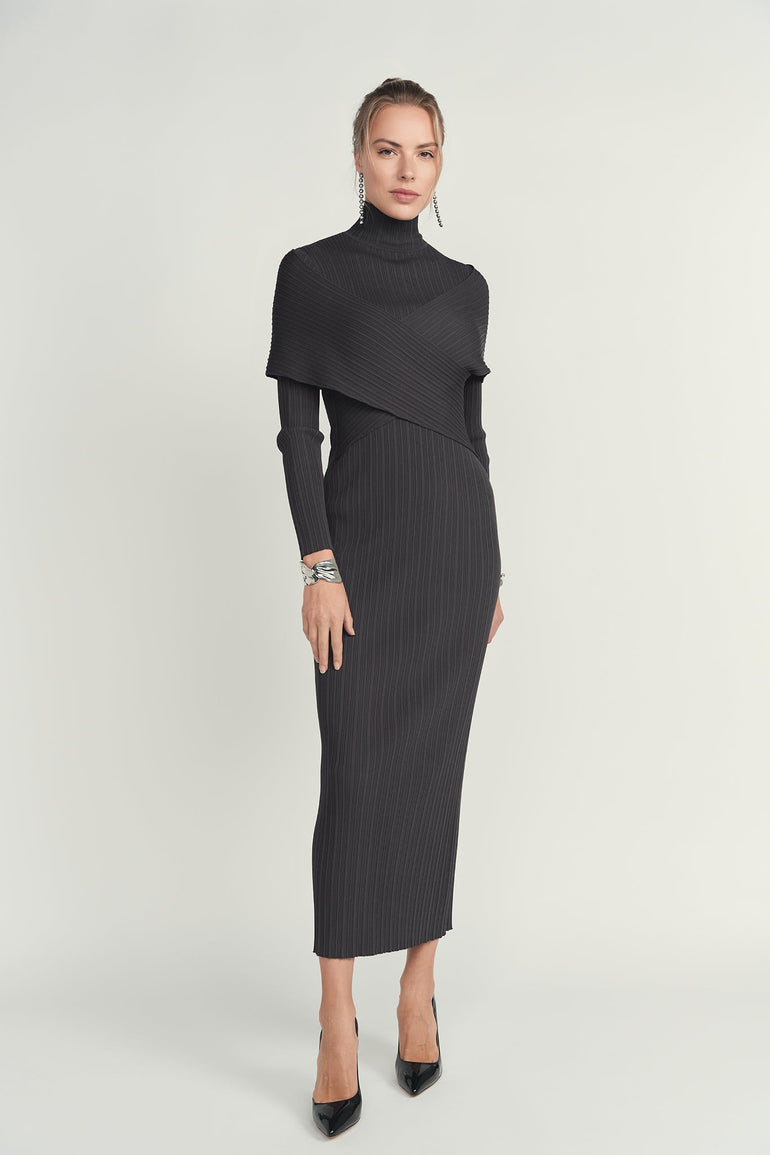 Woman wearing a black ribbed dress with a turtleneck on a white background
